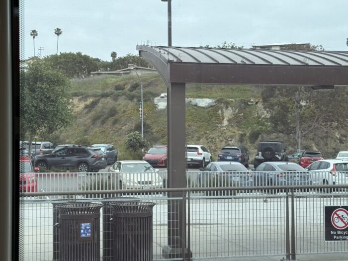 View of a parking lot from inside a San Diego Trolley train.